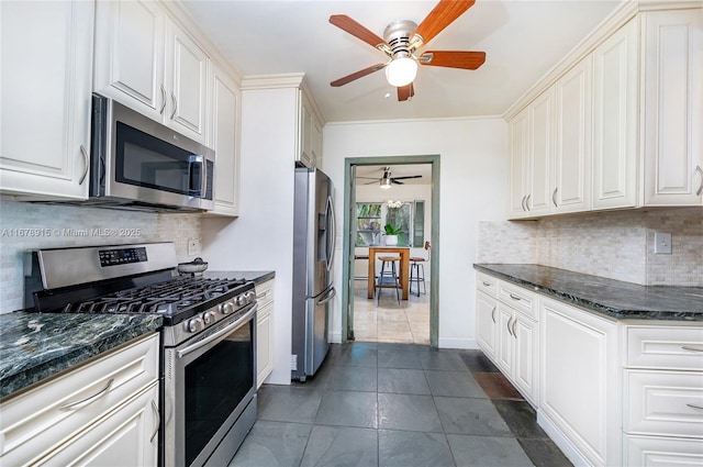 kitchen with dark stone countertops, white cabinetry, and appliances with stainless steel finishes