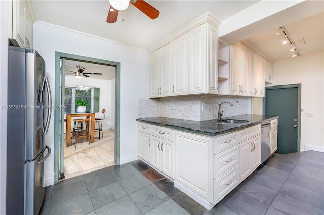 kitchen with white cabinets, decorative backsplash, sink, and stainless steel appliances