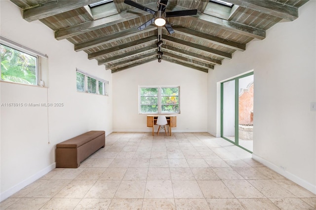 spare room featuring a wealth of natural light, ceiling fan, wood ceiling, and vaulted ceiling with beams