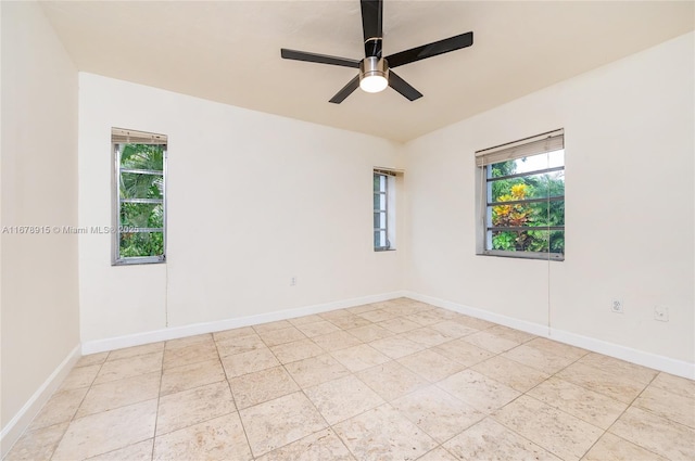 tiled spare room featuring ceiling fan