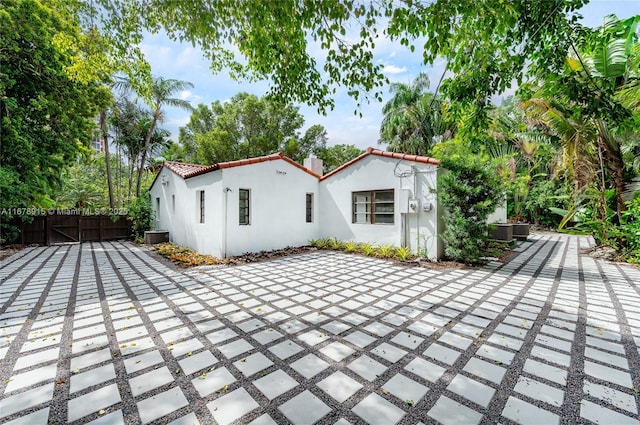 rear view of house with central air condition unit and a patio