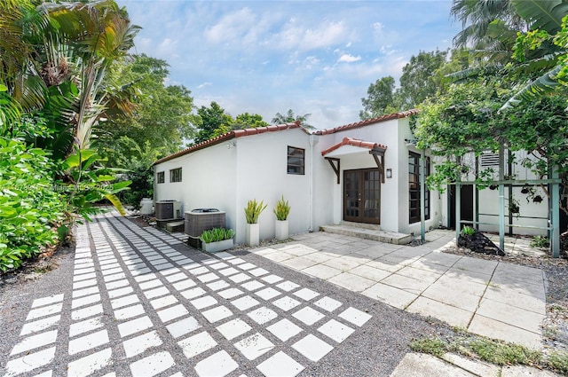 rear view of house featuring central air condition unit, a patio area, and french doors