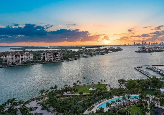 aerial view at dusk featuring a water view