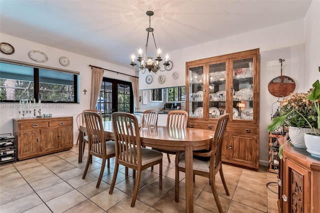 dining space featuring light tile patterned flooring, french doors, and a notable chandelier
