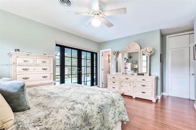 bedroom featuring access to outside, a ceiling fan, visible vents, french doors, and wood finished floors