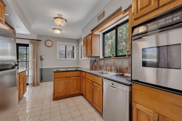 7901 SW 133rd St, Pinecrest, FL 33156 - kitchen featuring stainless steel appliances, light tile patterned floors, and brown cabinetry