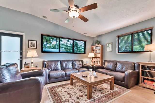 living room with lofted ceiling, wood finished floors, and a ceiling fan