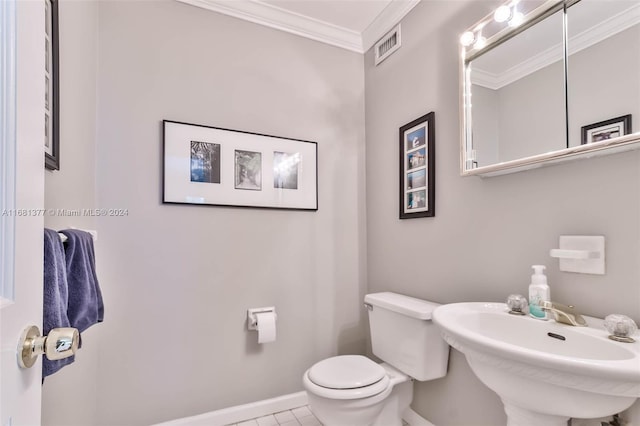 bathroom featuring a sink, visible vents, baseboards, toilet, and ornamental molding