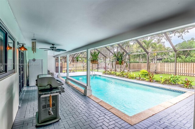 view of pool featuring a fenced in pool, a patio area, glass enclosure, ceiling fan, and a fenced backyard