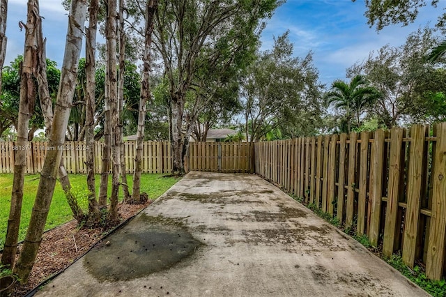 view of patio featuring fence and driveway