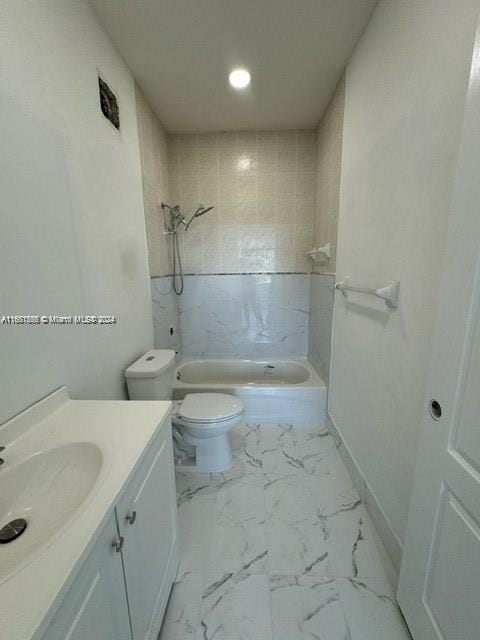 full bathroom with vanity, toilet, and tiled shower / bath combo