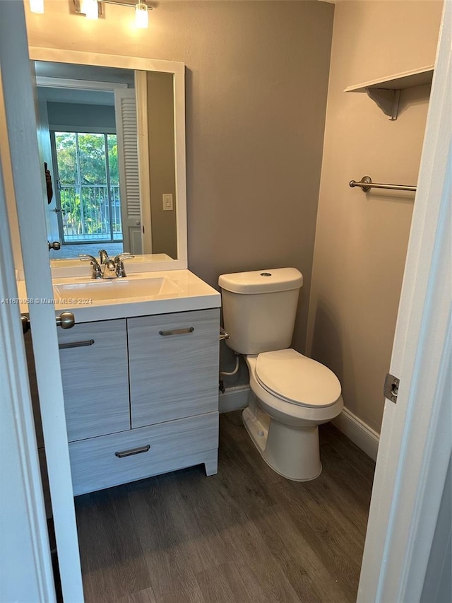 bathroom with hardwood / wood-style floors, vanity, and toilet