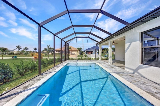 view of pool featuring a yard, a patio area, and glass enclosure