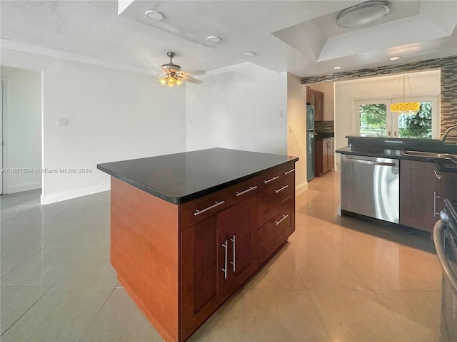 kitchen with light tile patterned floors, a textured ceiling, stainless steel appliances, sink, and a center island