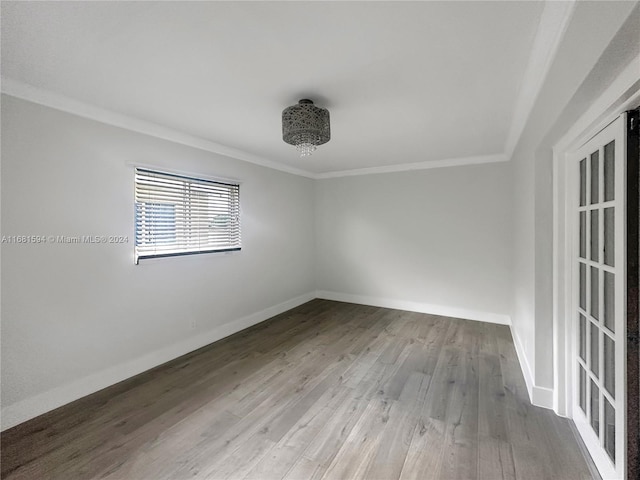 spare room featuring crown molding and light wood-type flooring