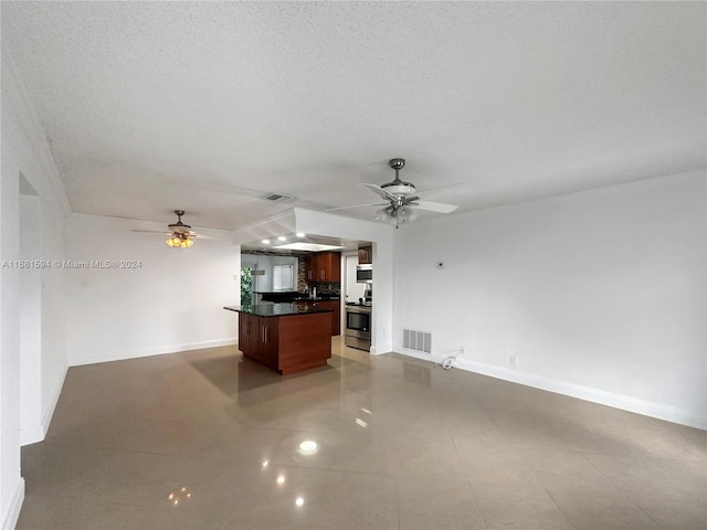 kitchen featuring a kitchen island, a textured ceiling, ceiling fan, stainless steel stove, and light tile patterned floors