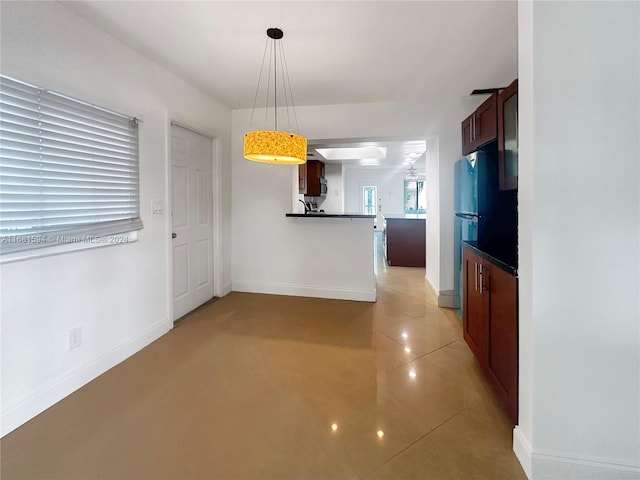 interior space featuring light tile patterned floors, kitchen peninsula, and hanging light fixtures