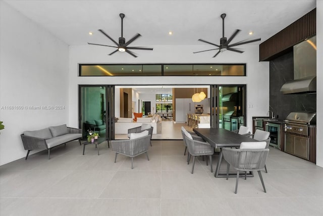 view of patio with wine cooler, ceiling fan, an outdoor living space, sink, and a grill