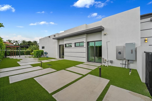 rear view of property featuring a patio area and a lawn