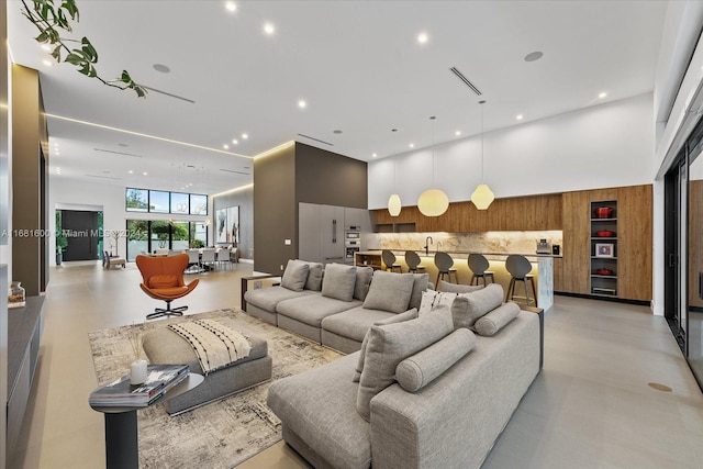 living room with a towering ceiling and sink