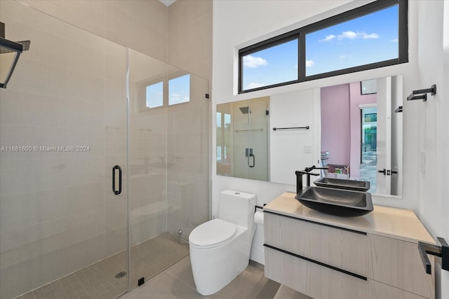 bathroom featuring vanity, a shower with shower door, toilet, and tile patterned flooring