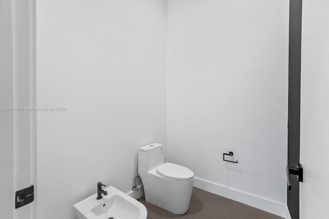 bathroom featuring toilet, sink, and a bidet