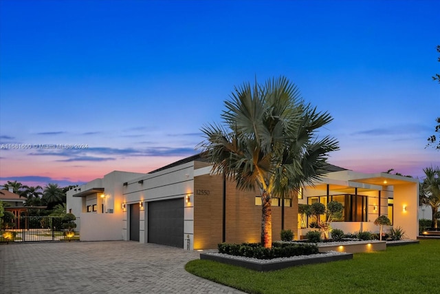 view of front of house featuring a garage and a lawn