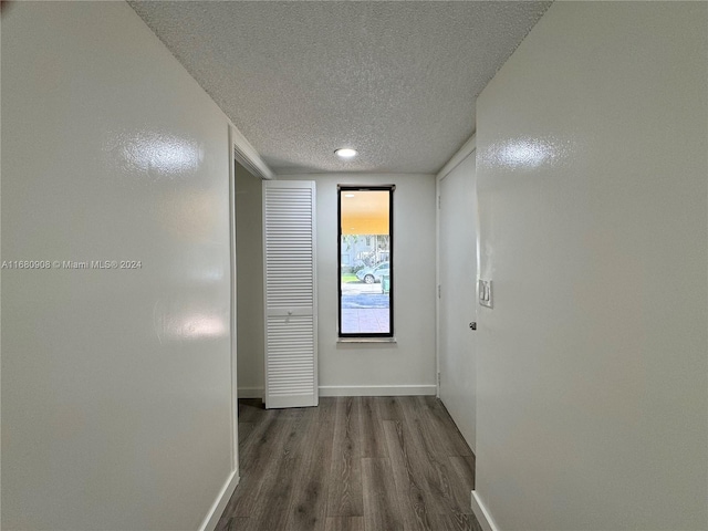 corridor featuring hardwood / wood-style flooring and a textured ceiling