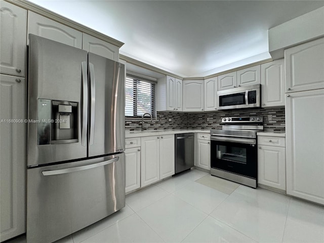 kitchen with sink, tasteful backsplash, stainless steel appliances, and light tile patterned floors