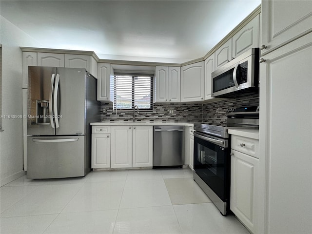 kitchen featuring light tile patterned floors, appliances with stainless steel finishes, sink, and backsplash