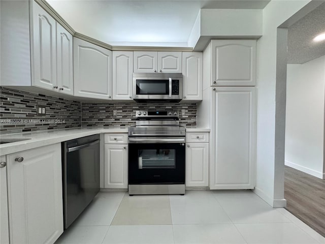 kitchen featuring appliances with stainless steel finishes, white cabinets, and light tile patterned floors