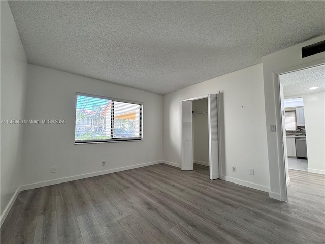 unfurnished bedroom featuring hardwood / wood-style floors and a textured ceiling