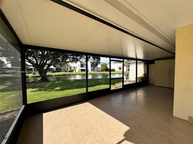 unfurnished sunroom with a water view