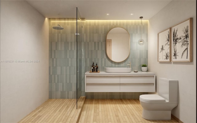 bathroom with toilet, vanity, a shower, and tile walls