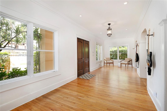 foyer featuring crown molding and light hardwood / wood-style floors