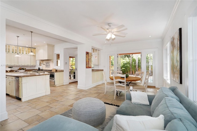 living room with ornamental molding, sink, and ceiling fan