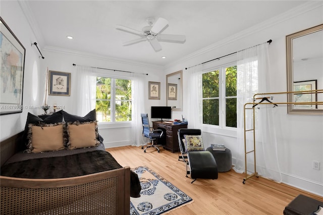 bedroom featuring ornamental molding, ceiling fan, multiple windows, and hardwood / wood-style flooring