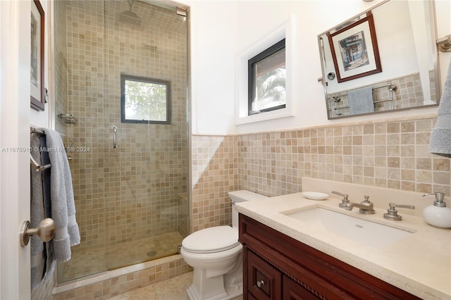 bathroom with an enclosed shower, toilet, tile walls, vanity, and tile patterned flooring