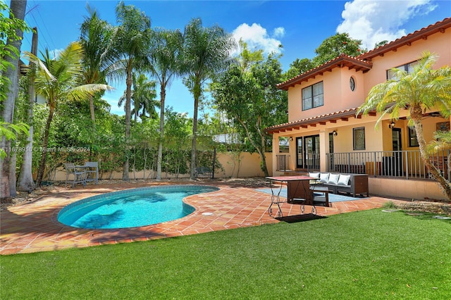 view of pool featuring outdoor lounge area, a patio area, and a lawn