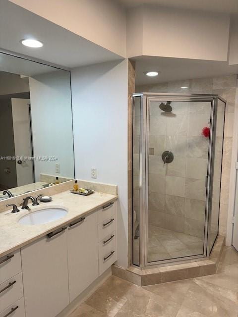 bathroom with vanity and a shower with shower door