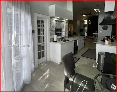 kitchen featuring white cabinetry, ceiling fan, and black cooktop