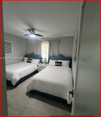 bedroom with ceiling fan and concrete flooring