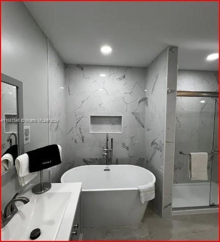 bathroom featuring vanity, concrete floors, and independent shower and bath