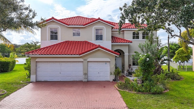 mediterranean / spanish-style house with a garage and a front lawn