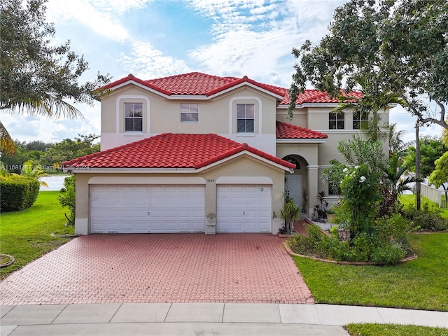 mediterranean / spanish home with a front lawn and a garage