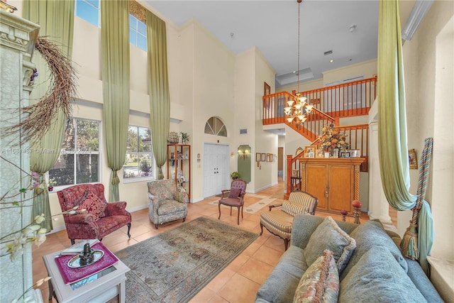 tiled living room with a high ceiling, a chandelier, and ornamental molding