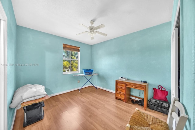 living area featuring light hardwood / wood-style floors and ceiling fan