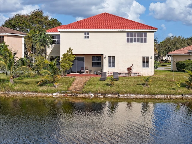 rear view of property with a water view and a lawn