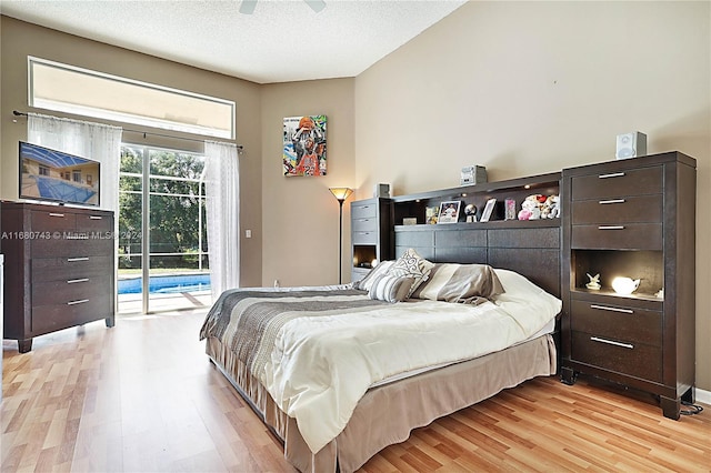 bedroom featuring ceiling fan, a textured ceiling, access to outside, and light hardwood / wood-style flooring