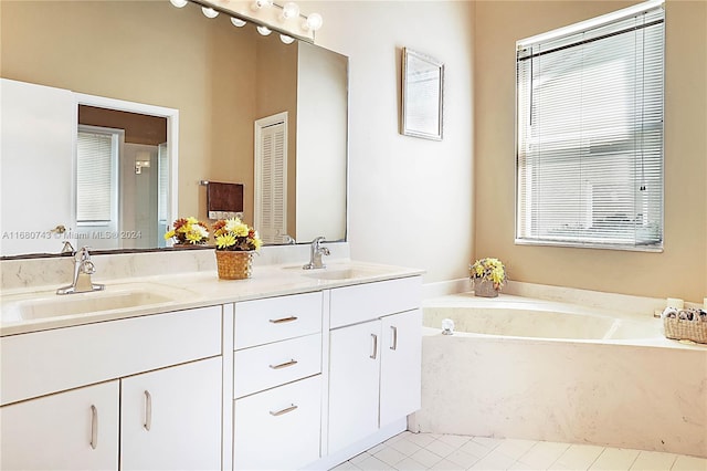 bathroom featuring tile patterned flooring, vanity, and a tub